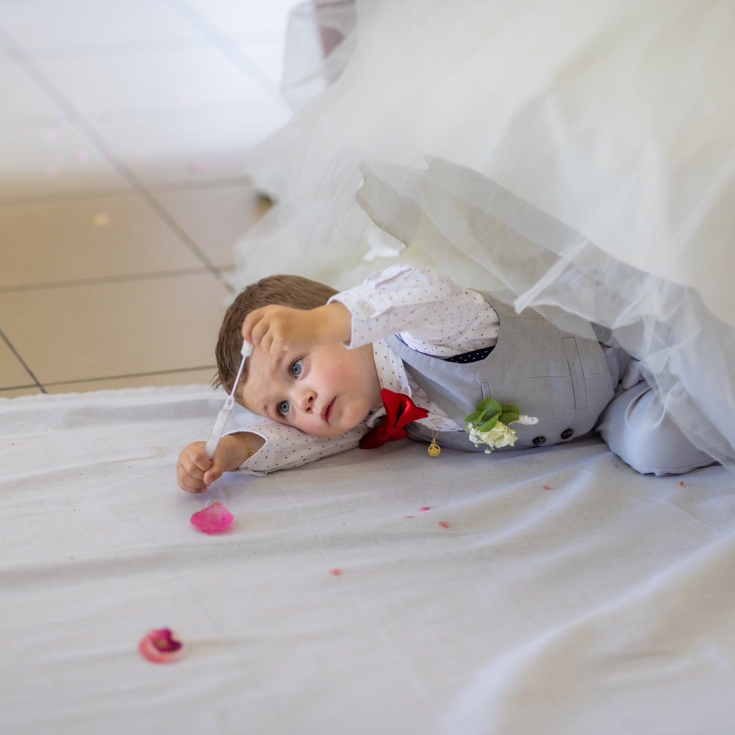 Photo de mariage à Toulouse – Petit garçons qui joue dans la robe de la mariée